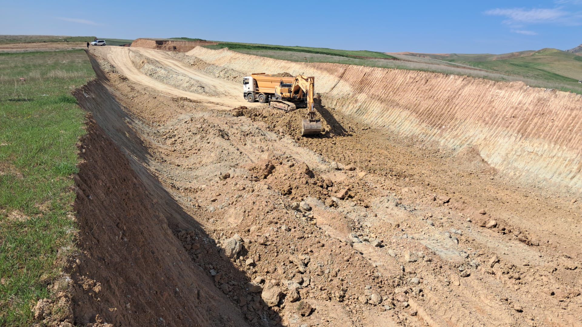 Altyapı hattı kazı çalışması — ekskavatör ve kamyon