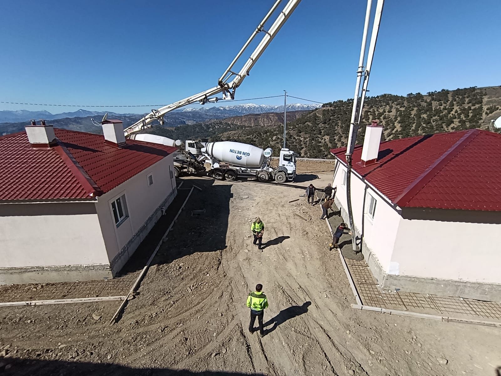 Köy ve sosyal konut serisi — beton dökümü, dağ manzarası