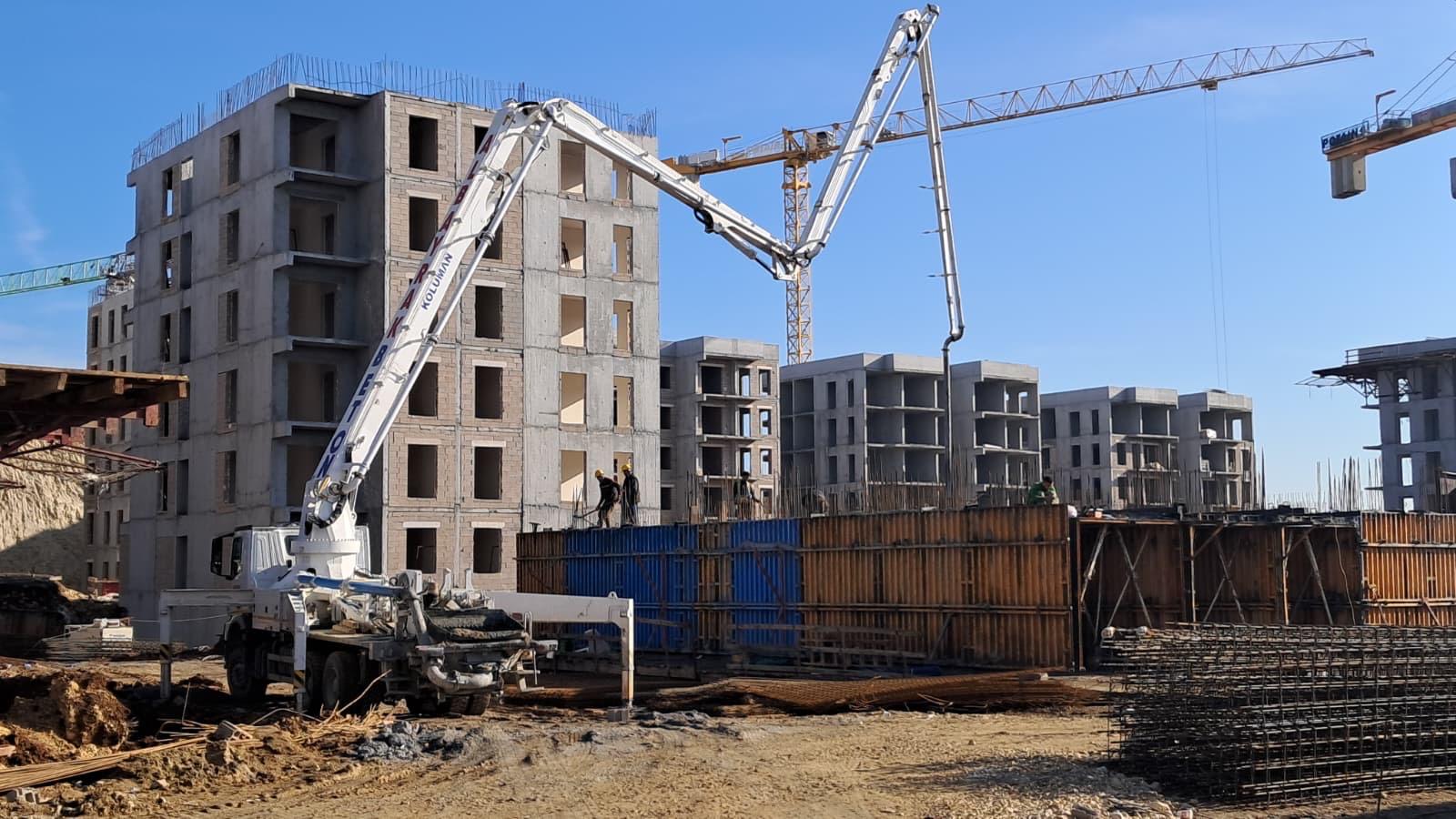 Çok katlı toplu konut şantiyesi — kule vinç ve beton pompası